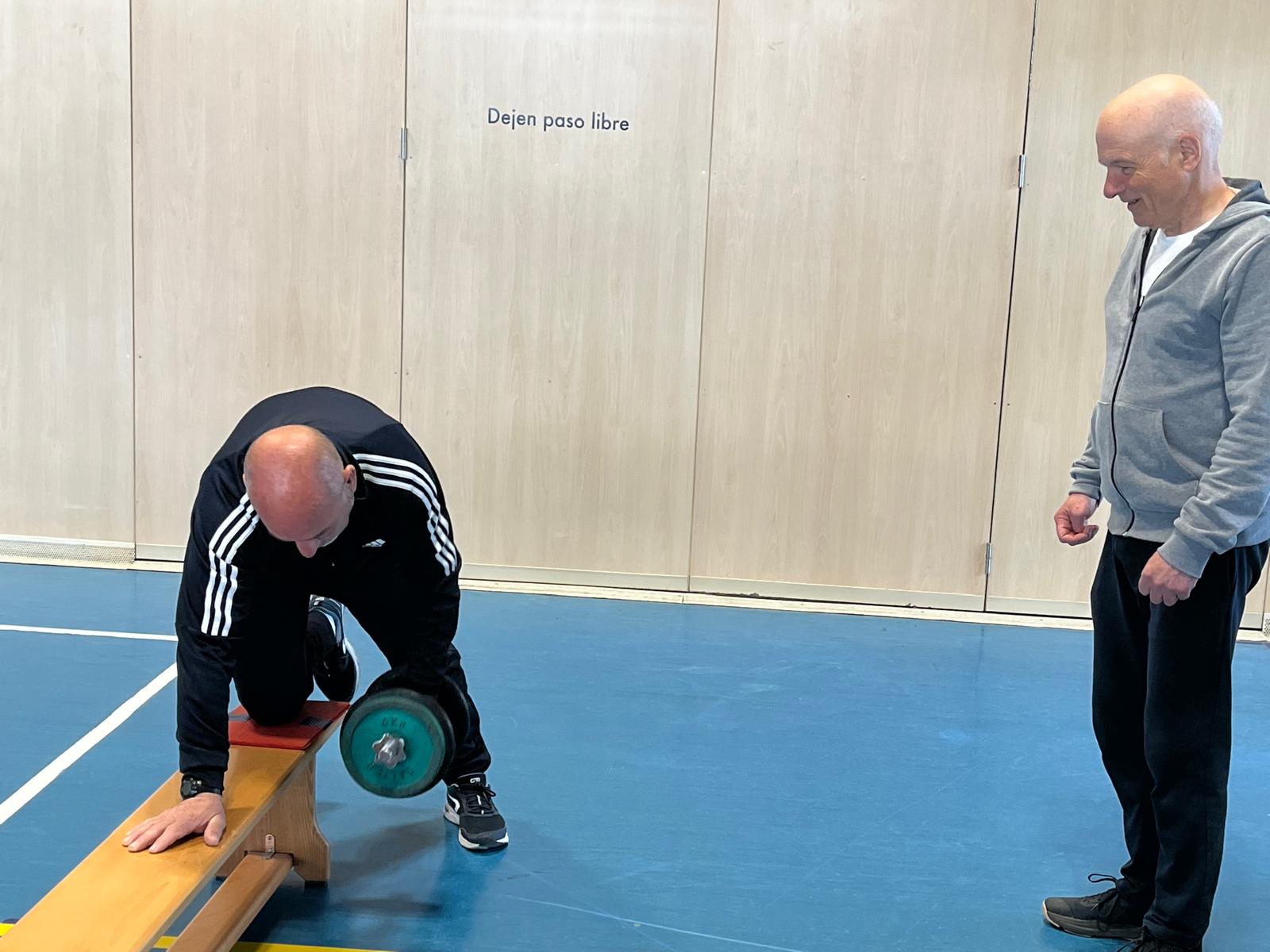 Dos compañeros ejercitándose juntos en el gimnasio