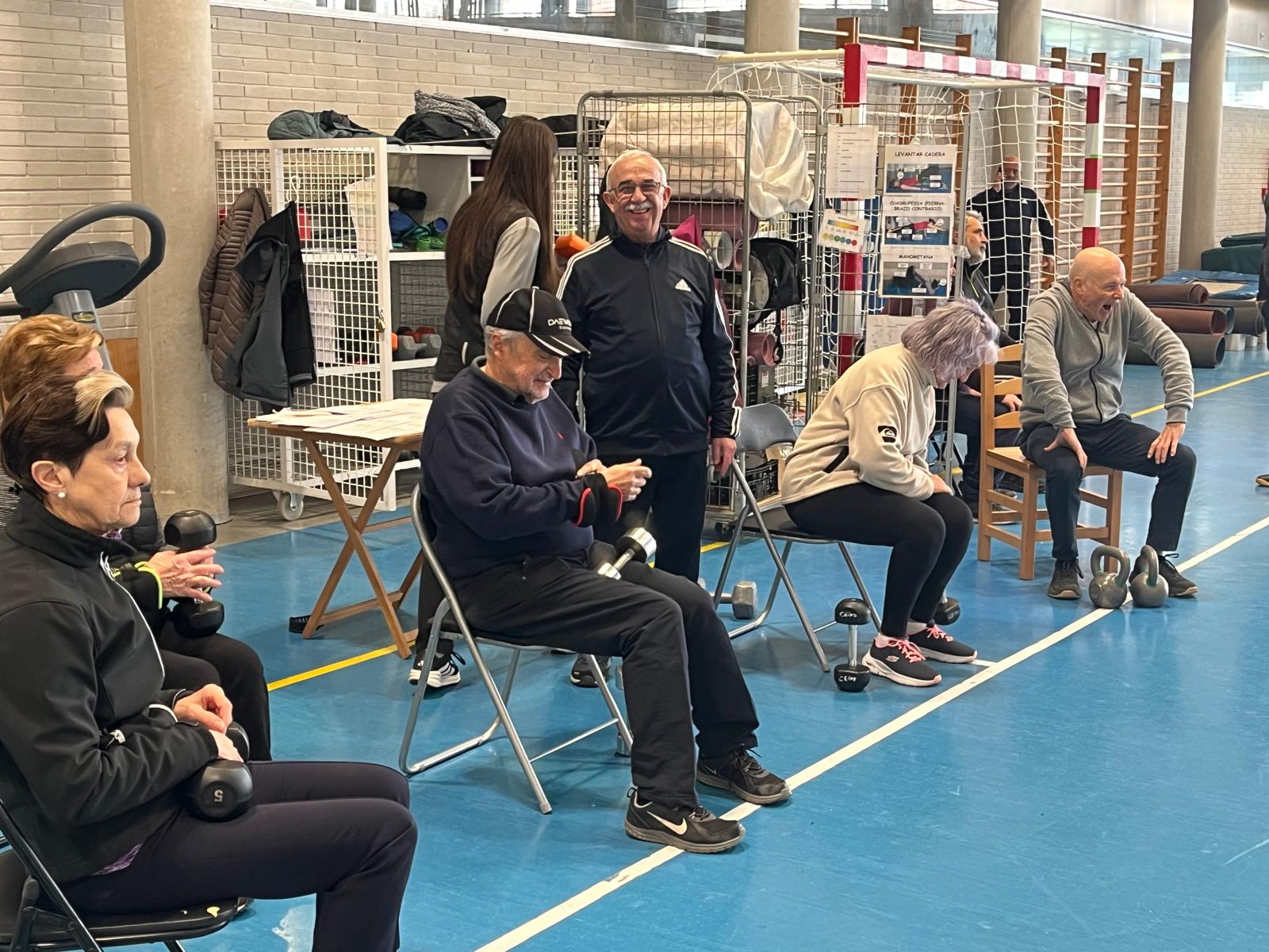 Grupo de participantes ejercitándose con kettlebells junto a su instructor